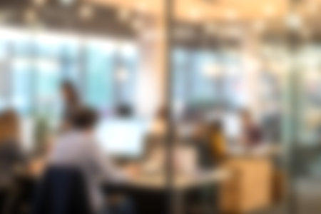 An energetic office scene showcasing diverse professionals engaged in work and collaboration, featuring modern desks and a vibrant atmosphere filled with light.の写真素材