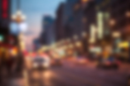 A mesmerizing blurred view of a bustling city street at dusk, filled with vibrant lights and dynamic movement, capturing the essence of urban life.の写真素材