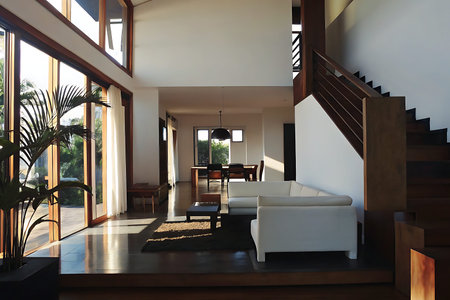 Bright and airy living room showcasing modern minimalist design, featuring large windows, a white sofa, and elegant wooden accents for a cozy atmosphere.の写真素材