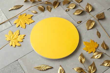A vibrant yellow circular display contrasts beautifully with golden leaves arranged on a textured...