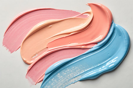 Vibrant swirls of pink, blue, and cream paint create a visually appealing abstract composition on a white background, ideal for artistic projects.の写真素材