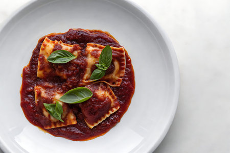 Enjoy a plate of delicious homemade ravioli smothered in a rich tomato sauce and garnished with...