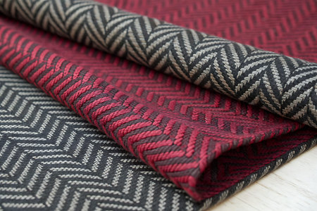 Close-up view of layered fabric showcasing a geometric pattern in red, black, and beige. Ideal for...
