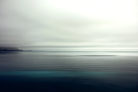 A serene coastal landscape featuring gentle waves under a soft, overcast sky. The tranquil water reflects a sense of calm and beauty, perfect for nature lovers.の写真素材