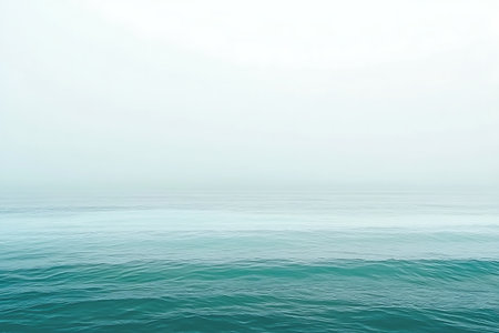 Experience the quiet beauty of tranquil waters under a soft misty sky, creating a peaceful and serene atmosphere ideal for relaxation and contemplation.の写真素材