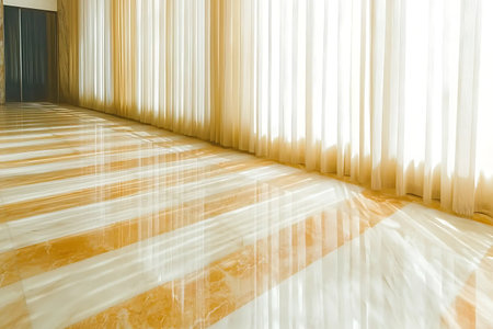 A beautiful interior space featuring soft sheer curtains filtering sunlight and creating playfully patterned shadows on a polished floor.の写真素材