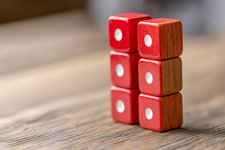 A close-up view of red wooden dice stacked on a rustic wooden surface, showcasing their vibrant color and smooth texture. Ideal for game-themed content.の写真素材