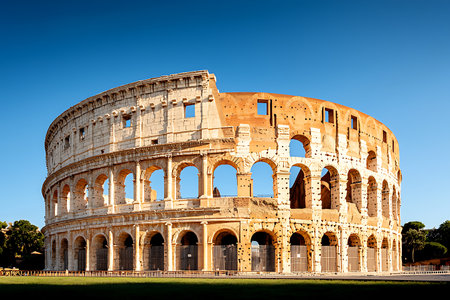 The image showcases the stunning Colosseum in Rome, an iconic symbol of ancient architecture, set against a clear blue sky, inviting exploration and admiration.の写真素材