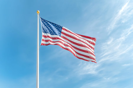 A vibrant American flag waves proudly against a clear blue sky, embodying national pride and freedom...