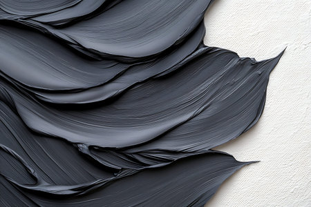 Close-up view of textured black paint on canvas, featuring flowing brush strokes that create depth and visual interest in art.の写真素材