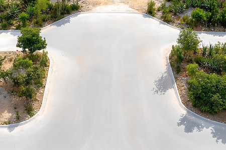 An overhead view of an intersection where roads meet, surrounded by lush greenery and natural elements, depicting an inviting landscape for exploration and travel.の写真素材