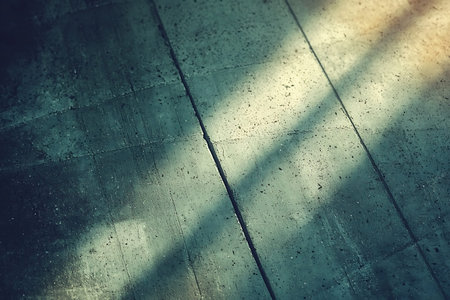 A captivating view of light and shadows interacting over a textured concrete surface, creating an artistic and serene mood perfect for minimalistic design ideas.の写真素材