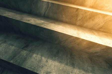 This image showcases textured concrete stairs illuminated by warm light, creating an inviting atmosphere. The interplay of light and shadow highlights the architectural features, ideal for various design and editorial projects.の写真素材