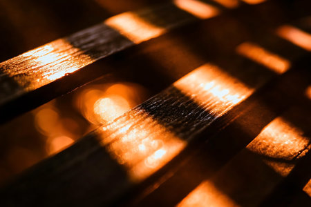 A stunning close-up of wooden slats bathed in warm glowing light, creating intricate shadow patterns...