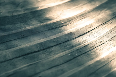 A close-up of a textured surface with gentle waves illuminated by soft light, showcasing intricate...