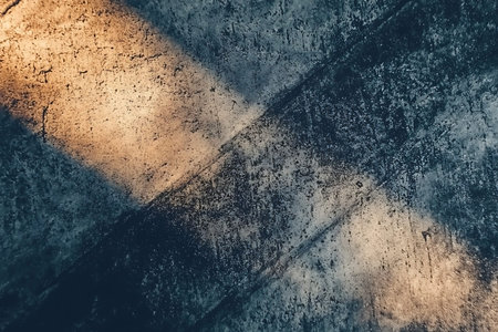 A close-up view of a textured concrete surface featuring light reflections and artistic shadow patterns. Ideal for creative and modern design projects.の写真素材