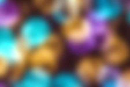 An artistic photo featuring a blend of vibrant circular bokeh lights in blue, purple, and gold, ideal for creating a lively and festive atmosphere.の写真素材