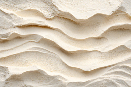 This image showcases a soft, creamy texture of fine sand, featuring elegant waves and undulating...
