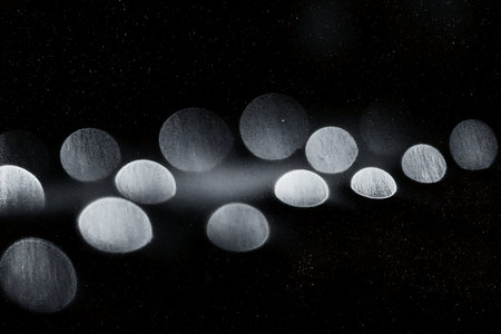 This captivating image features an abstract light bokeh effect with soft focus on a dark background,...