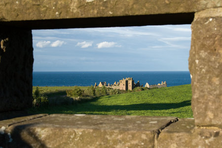Castle ruin framed by a stone wallの写真素材