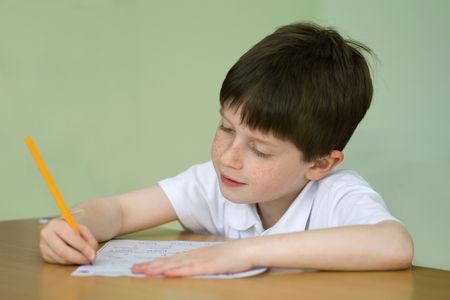 Young boy at a table doing school workの写真素材