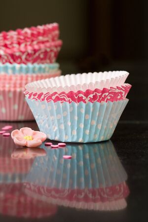 Colorful paper cupcake cases on a kitchen worktopの写真素材