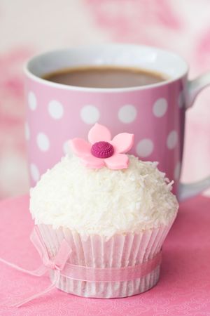Cupcake decorated with dessicated coconut and a sugar flowerの写真素材