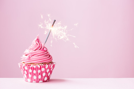 Pink cupcake decorated with a sparklerの写真素材