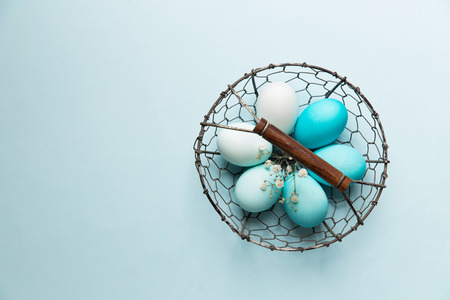 Easter eggs in a wire basketの写真素材