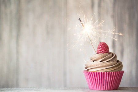 Cupcake decorated with chocolate buttercream and a sparklerの写真素材
