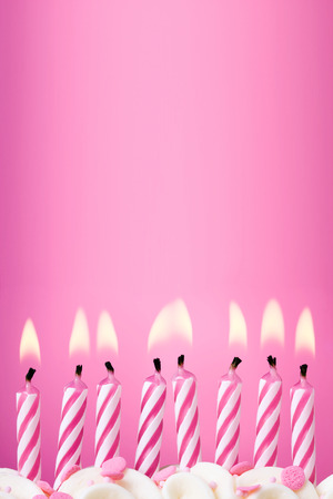 Eight birthday candles against a pink backgroundの写真素材