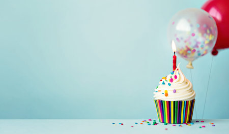 Birthday cupcake with colorful balloons and confetti