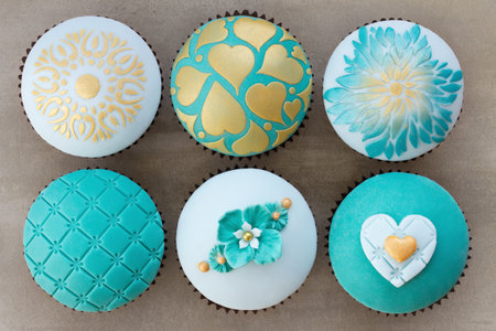 Wedding cupcakes decorated with teal and gold embossed fondantの写真素材