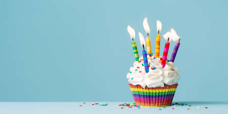 Birthday cupcake with lots of colorful birthday candlesの写真素材