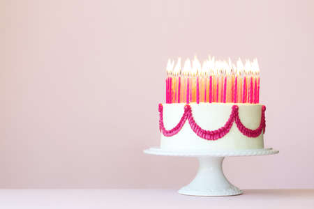 Birthday cake with lots of pink birthday candlesの写真素材