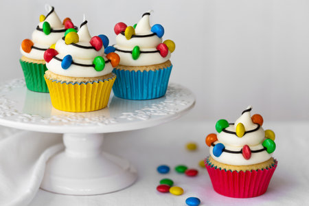 Cakestand with Christmas cupcakes decorated with strings of colorful candy Christmas lightsの写真素材