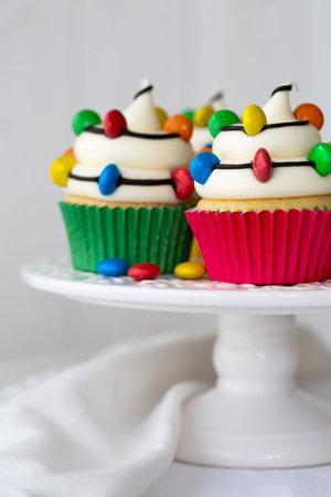 Cakestand with Christmas cupcakes decorated with colorful Christmas lightsの写真素材