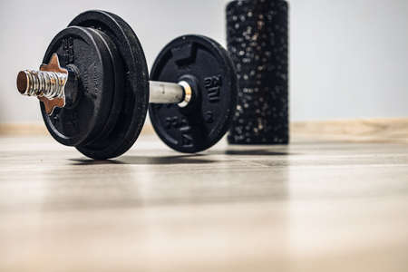 a dumbbell for exercises and a back roller waiting for training. home fitness and motivation. no person. new year's resolutionsの写真素材