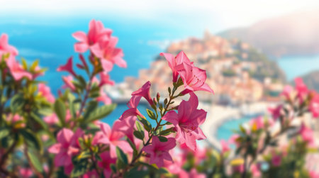Pink flowers in bloom with a coastal town in the background. A vibrant summer scene.の素材