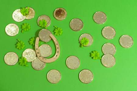 Golden horseshoe, gold coins and clover leaves on green boards. St. Patrick's day holiday symbol.の写真素材
