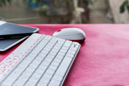 Keyboard, mouse and graphic tablet to design. On red table.