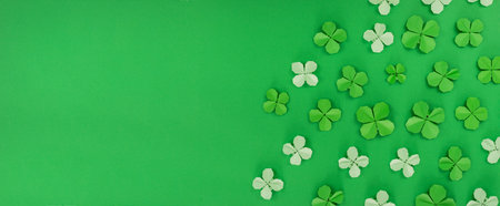 Saint Patrick's day banner with origami clovers leaves. Above view over a green background. Holiday symbol. Copyspace.の写真素材