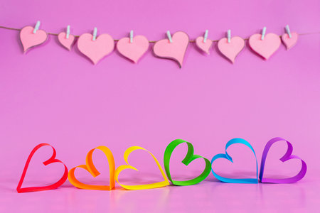 Love hearts with the colors of LGBT on pink background. Valentines day card concept. Heart for Valentines Day Background. Select focus. Soft focus.の写真素材