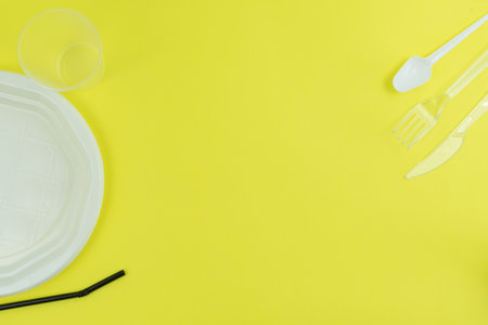 Top view of plastic objects for recycling on a yellow background.の写真素材