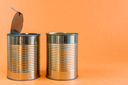 Empty metal cans and tins on an orange background. Recycling concept and environment.
