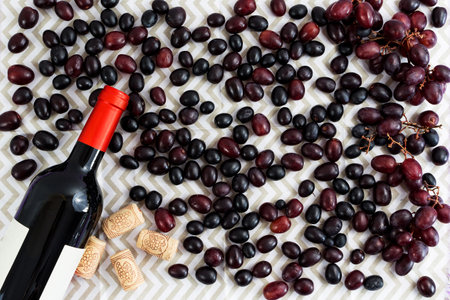 grapes and bottle of wine on white background and corks. zenith view.の写真素材