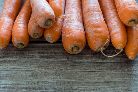 Freshly washed whole carrots on wooden table in Garden. Vegetables Vitamins Keratin. Natural Organic Carrot on Wooden background Top View. Copy textspace.の写真素材