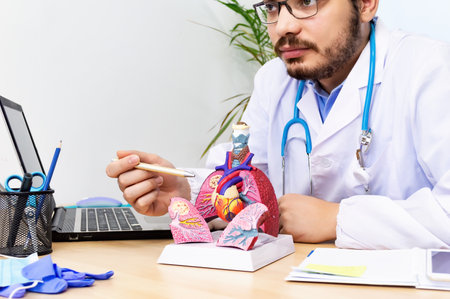 Doctor cardiologist while consultation showing anatomical model of human heart.の写真素材