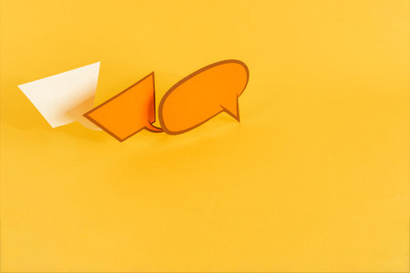 Three paper speech bubbles on yellow background.の写真素材