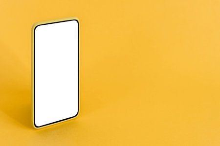 Isolated smart phone with blank screen, on yellow background.の写真素材